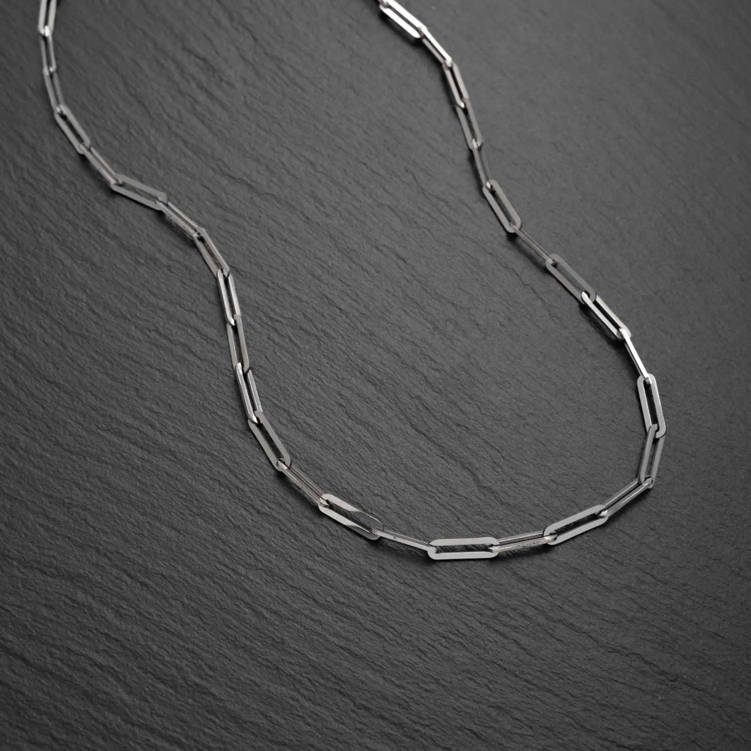 Herren Paperclip Halskette in 3,5mm breite aus Edelstahl mit Gliedern in Form von Büroklammern auf einem schwarzen rauen Hintergrund