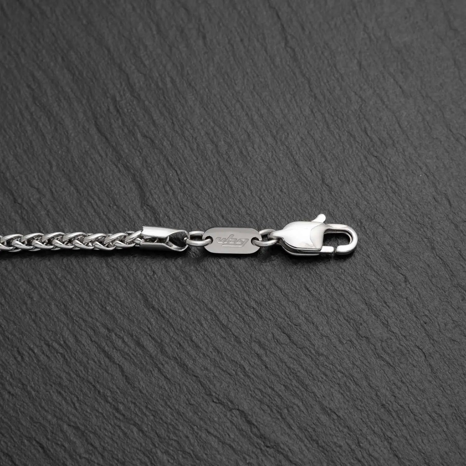 Herren Armband mit Kettengliedern in Wheat Struktur in 3mm Breite aus Edelstahl auf einem schwarzen rauen Hintergrund