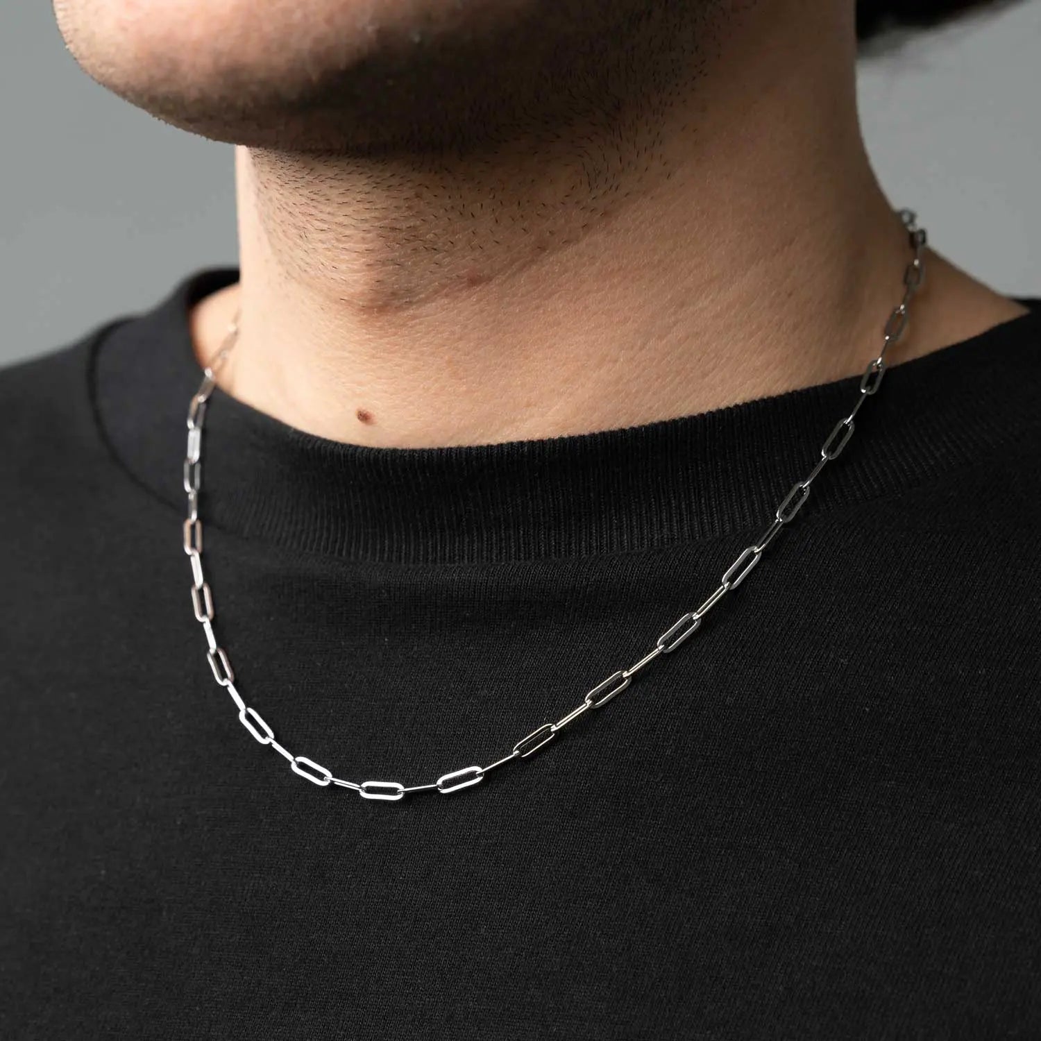 Paperclip Halskett mit Gliedern in Form von Büroklammern getragen von einer männlichen Person mit einem schwarzen T-Shirt