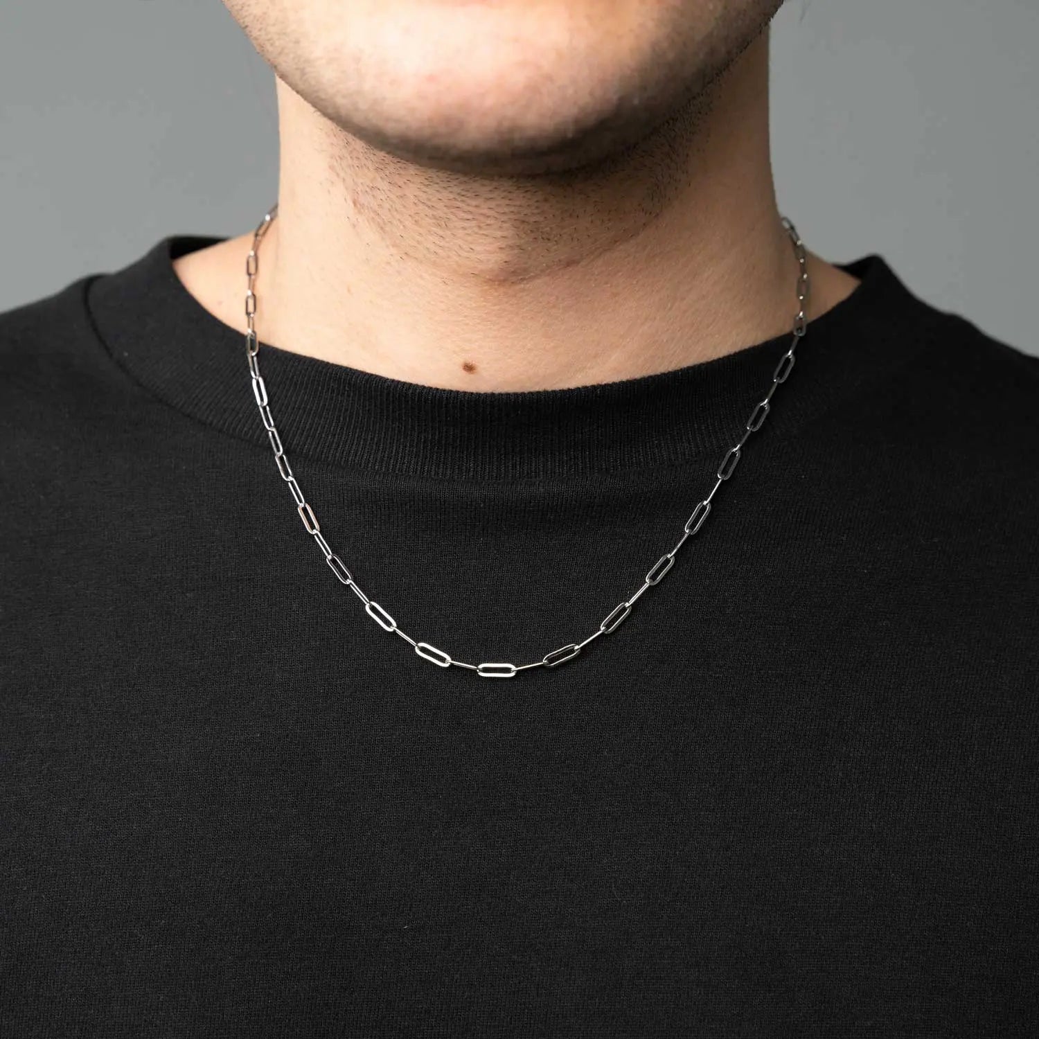 Paperclip Halskette mit breiten Gliedern im Büroklammer Stil getragen von einer männlichen Person mit einem schwarzen T-Shirt