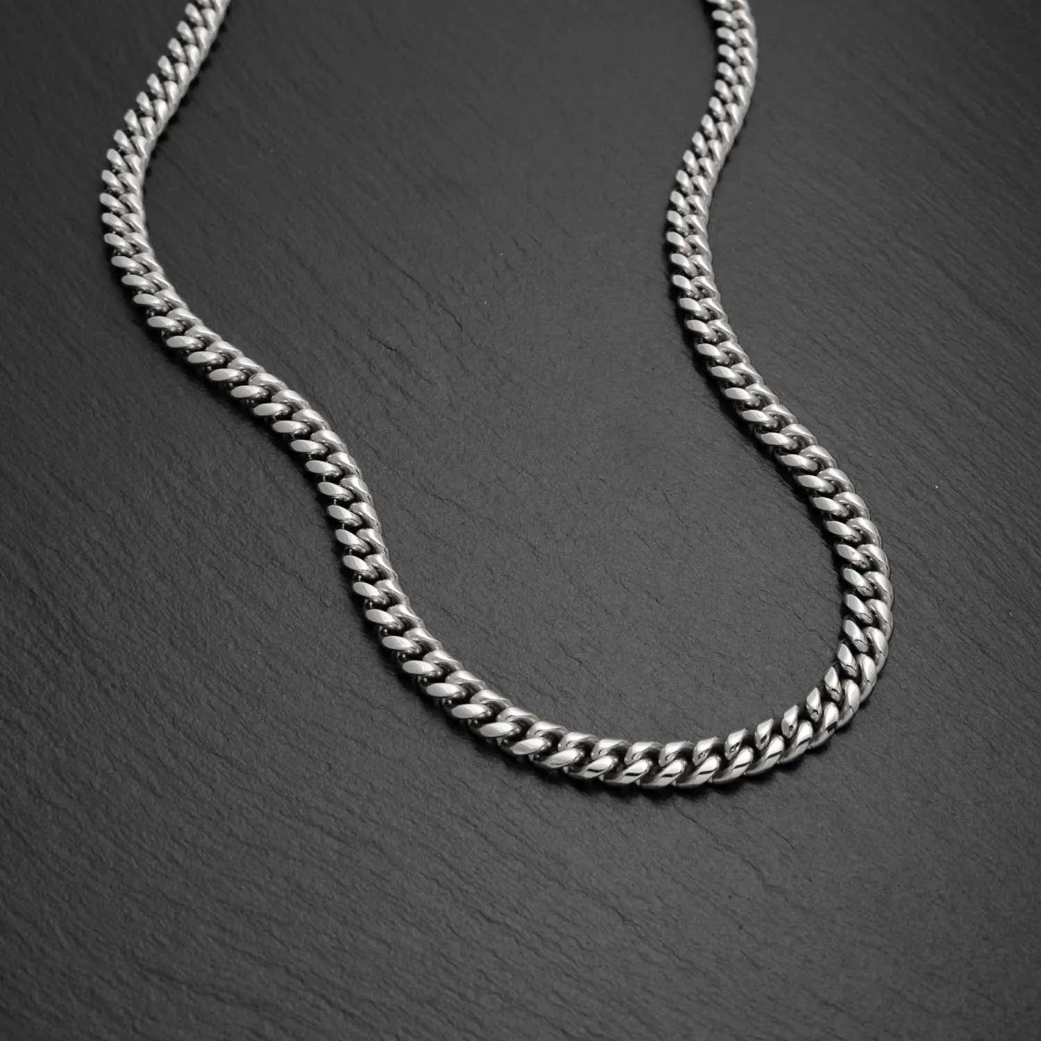 Herren Panzerkette Cuban Link in 4mm breite auf einem schwarzen rauen Hintergrund